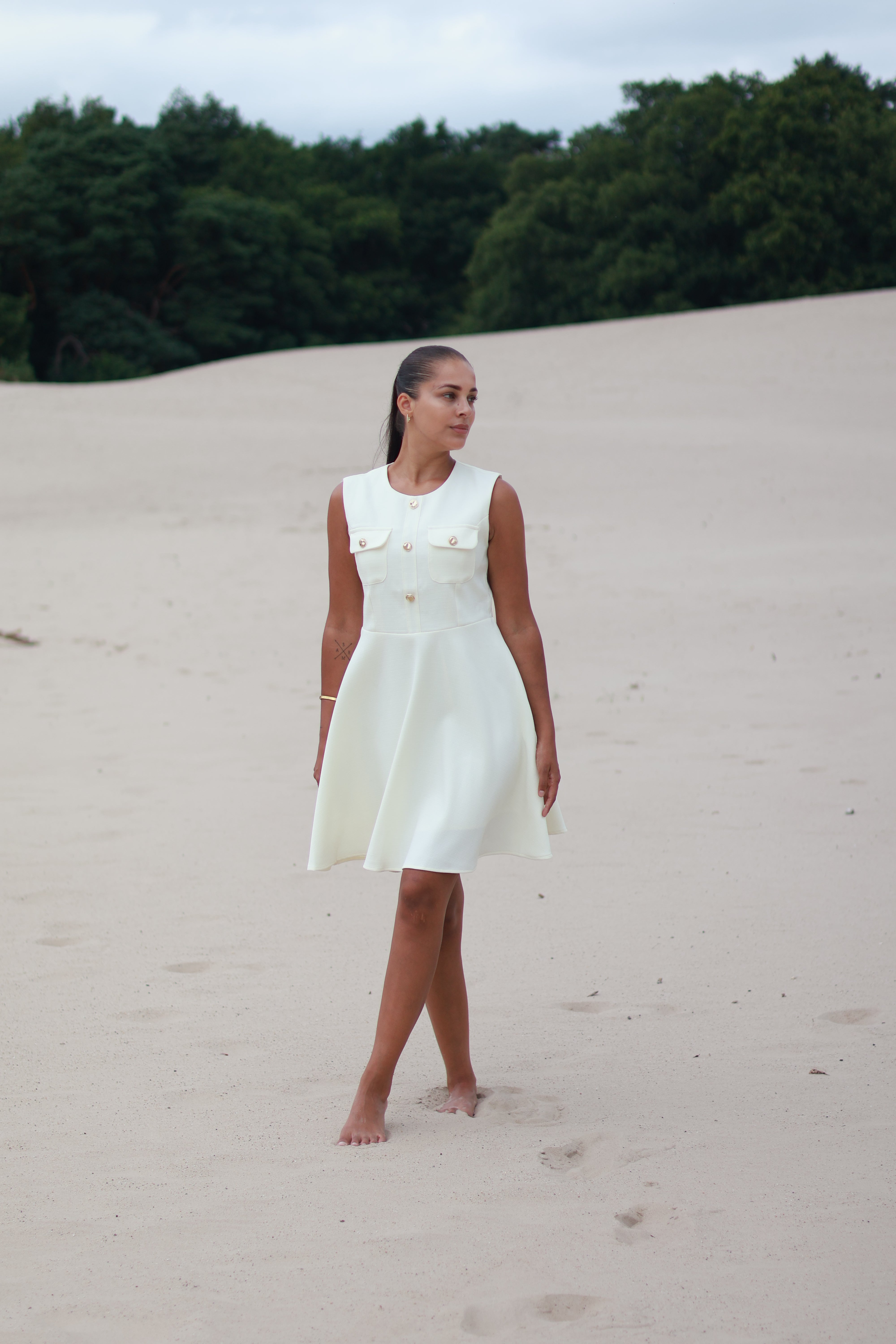 witte jurk met gouden knoopsluiting