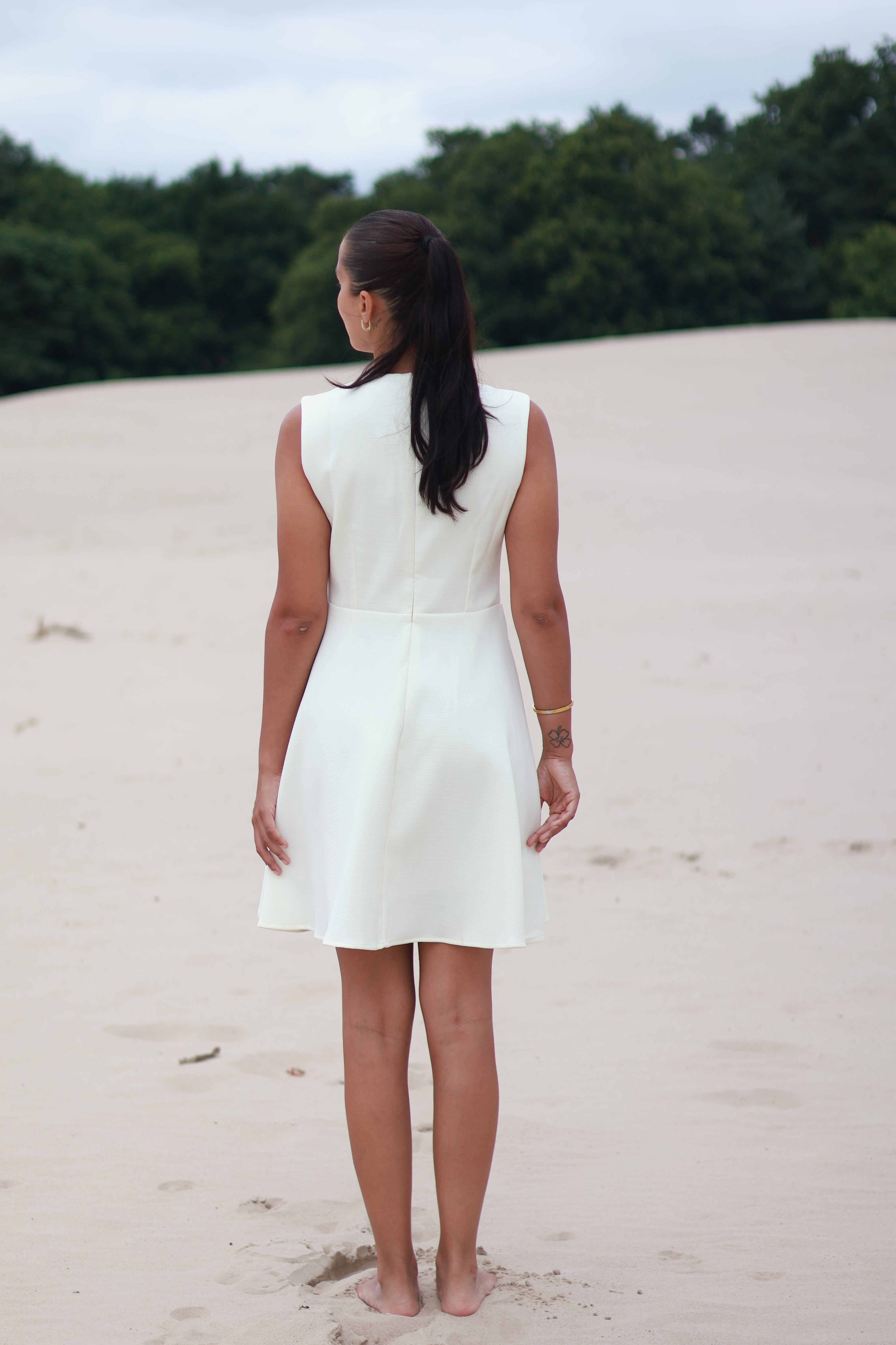 witte jurk met gouden knoopsluiting